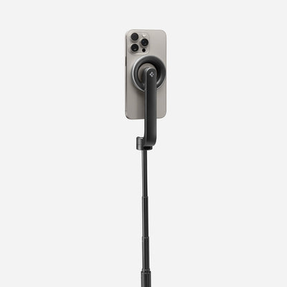AMP07659 - Tripod Selfie Stick (Mag Fit) | S580W in Black showing the back of an iPhone attached magnetically to the S580W selfie stick via the MagFit mount, with the stick fully extended against a light gray background.