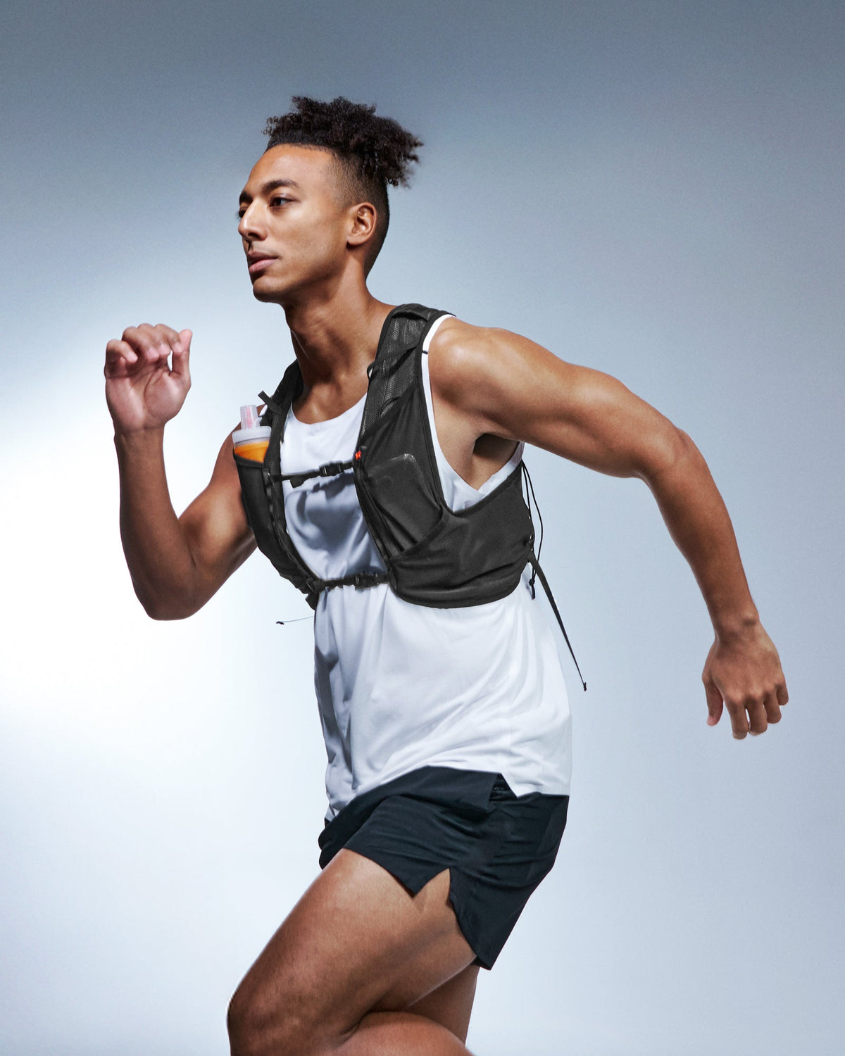 AMP10225 - Dynamic Shield™ Running Vest | A721 L-XL in Black worn by a runner in motion with a soft flask stored in the front pocket.