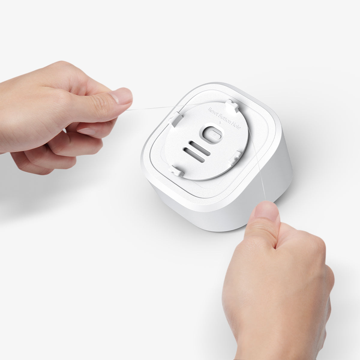 AMP09409 - Eero 6 Mount | ER110 in White showing the back, a person using a sturdy string to remove the bracket