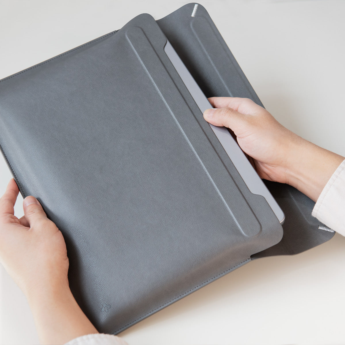 AFA06415 - MacBook Pro 14-inch Valentinus Laptop Pouch in City Gray showing case and laptop holding with hand