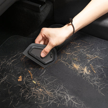 ACP11829 - Hand using the Spigen scraper to clear pine needles and debris from a car floor mat
