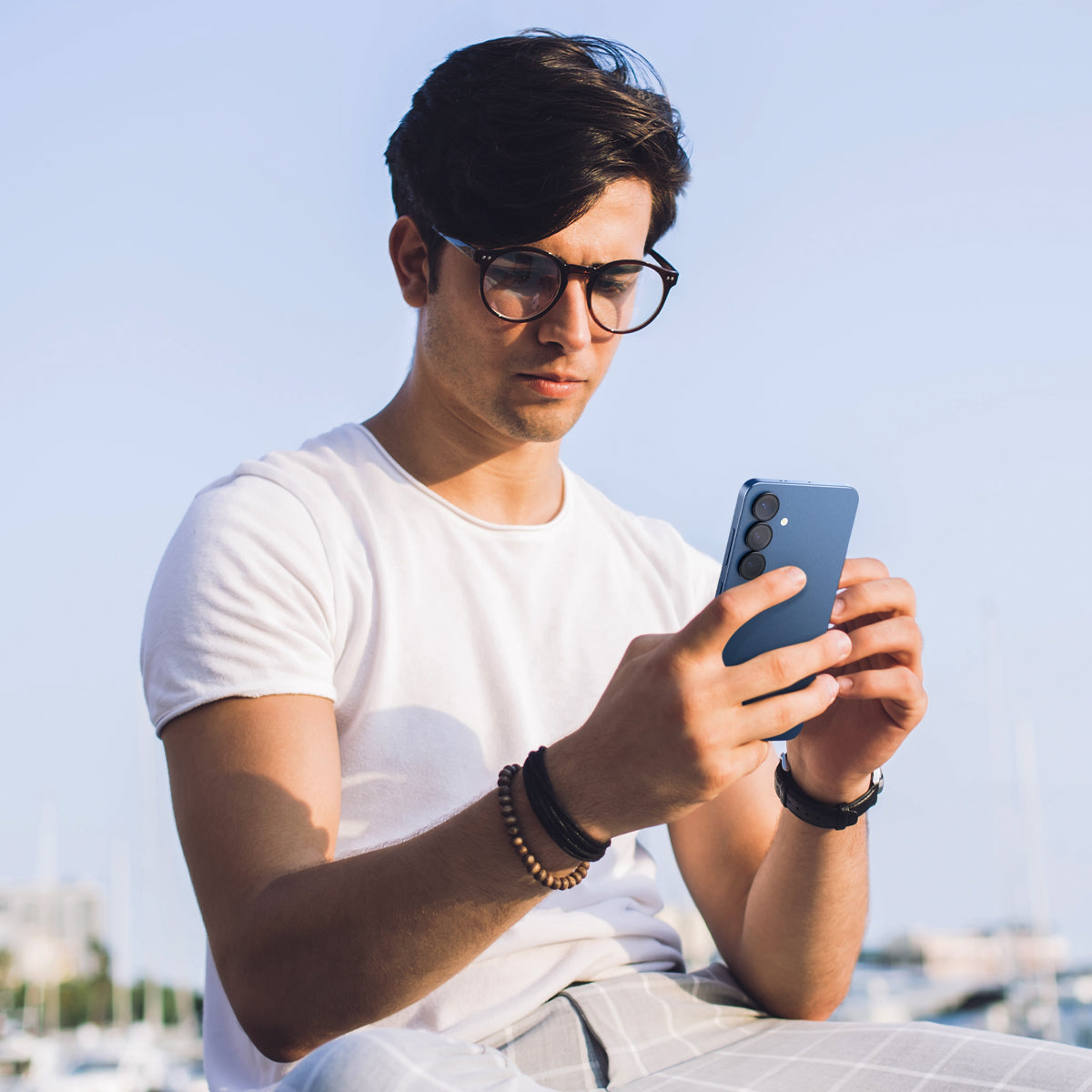 AGL09086 - Galaxy S25 Plus Optik Pro EZ Fit Lens Protector in Black showing a person holding the device