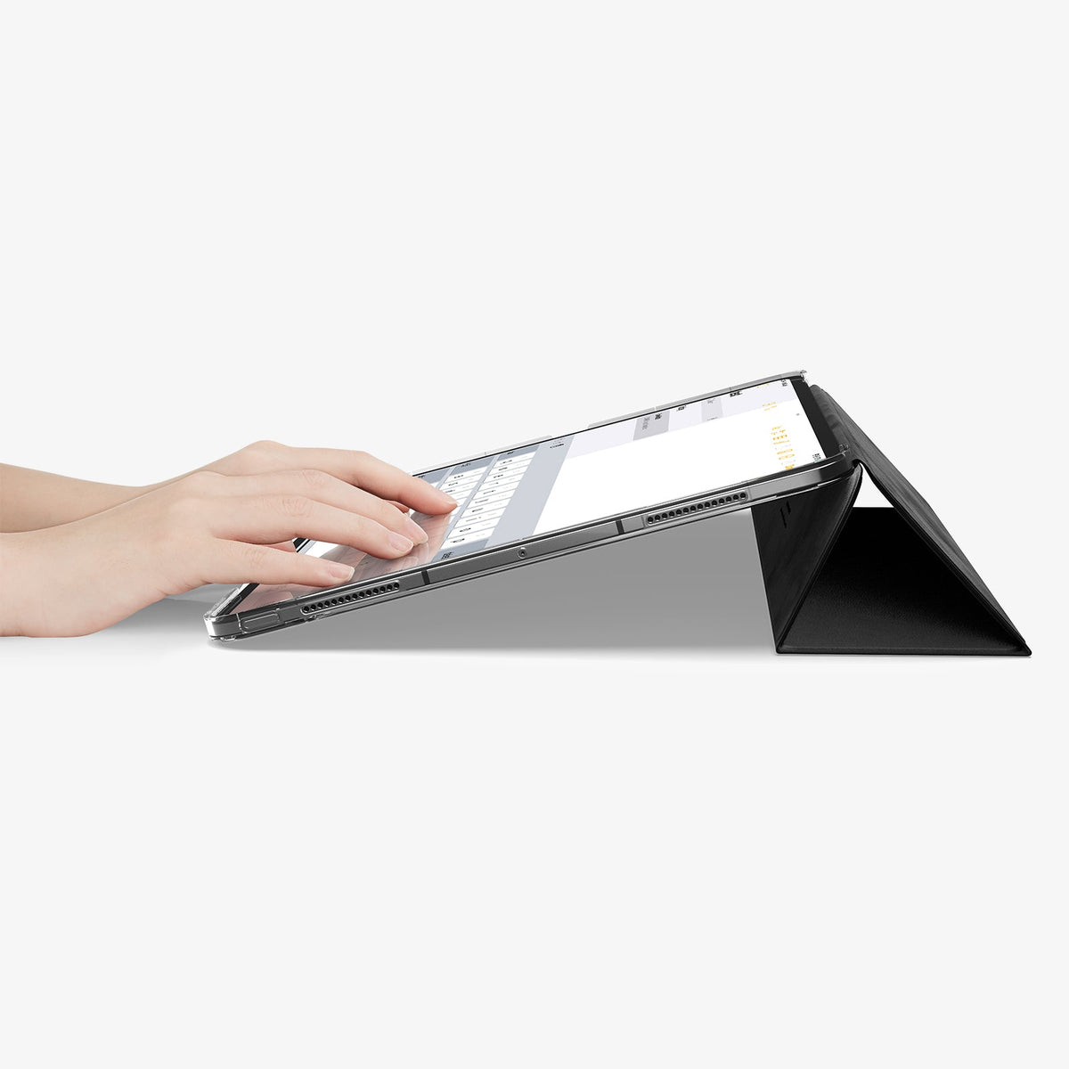 ACS09439 - iPad Pro 13-inch (2024) Case Liquid Air Folio in Black showing a person typing on the device while cover folded into a kickstand