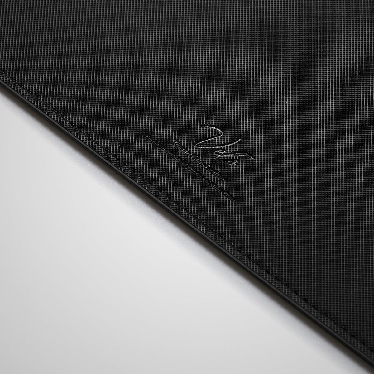 APP04762 - LD302 Desk Pad in black showing the back zoomed in on the vegan leather logo