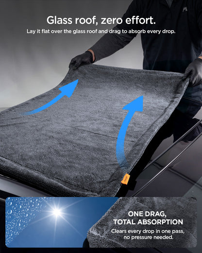 ACP11389 - Man dragging a Spigen microfiber towel flat across a car's glass roof to absorb water in one pass