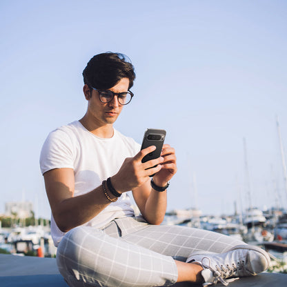 AGL08443 - Pixel 9 Case Optik EZ Fit Lens Protector in Crystal Clear showing a man holding the device with the installed lens protector